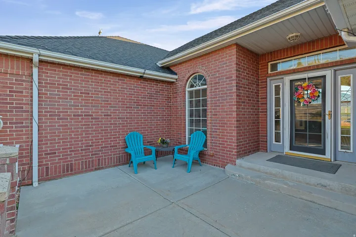 Brick exterior with a dark shingle roof and white gutters