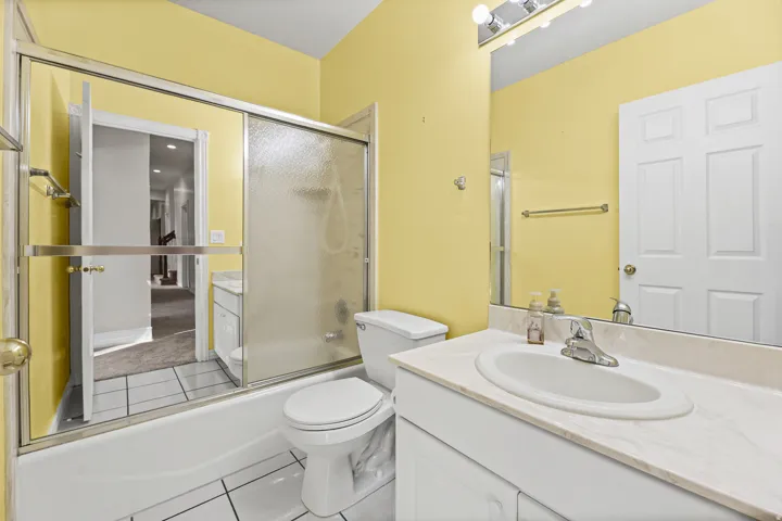 Bathroom featuring a white vanity with a built-in sink, an extended countertop, and a large mirror with overhead lighting