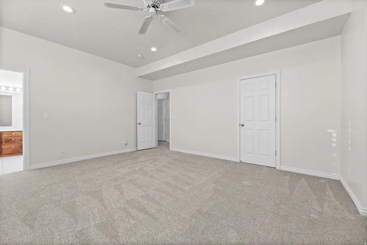 Spacious room featuring light-colored carpeting, recessed lighting, and a ceiling fan