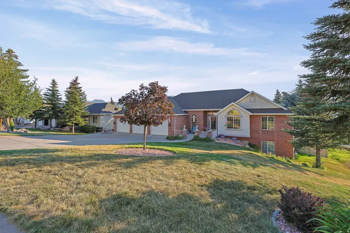 Brick and siding exterior featuring an arched window, a prominent front entrance, and an attached multi-car garage