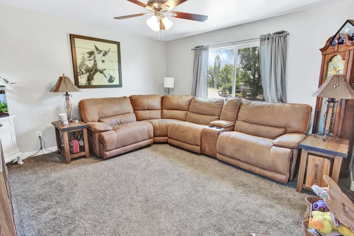 Spacious interior room featuring light gray wall paint and gray carpet flooring