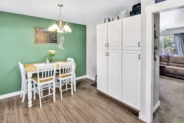 Dedicated dining area featuring wood-finish flooring and a contemporary chandelier