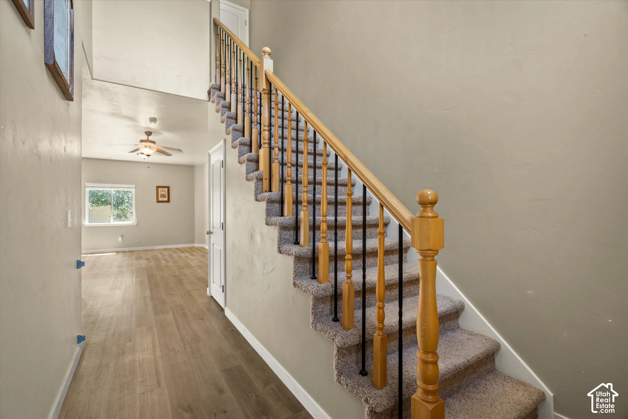 Carpeted staircase with wooden handrail and black metal balusters