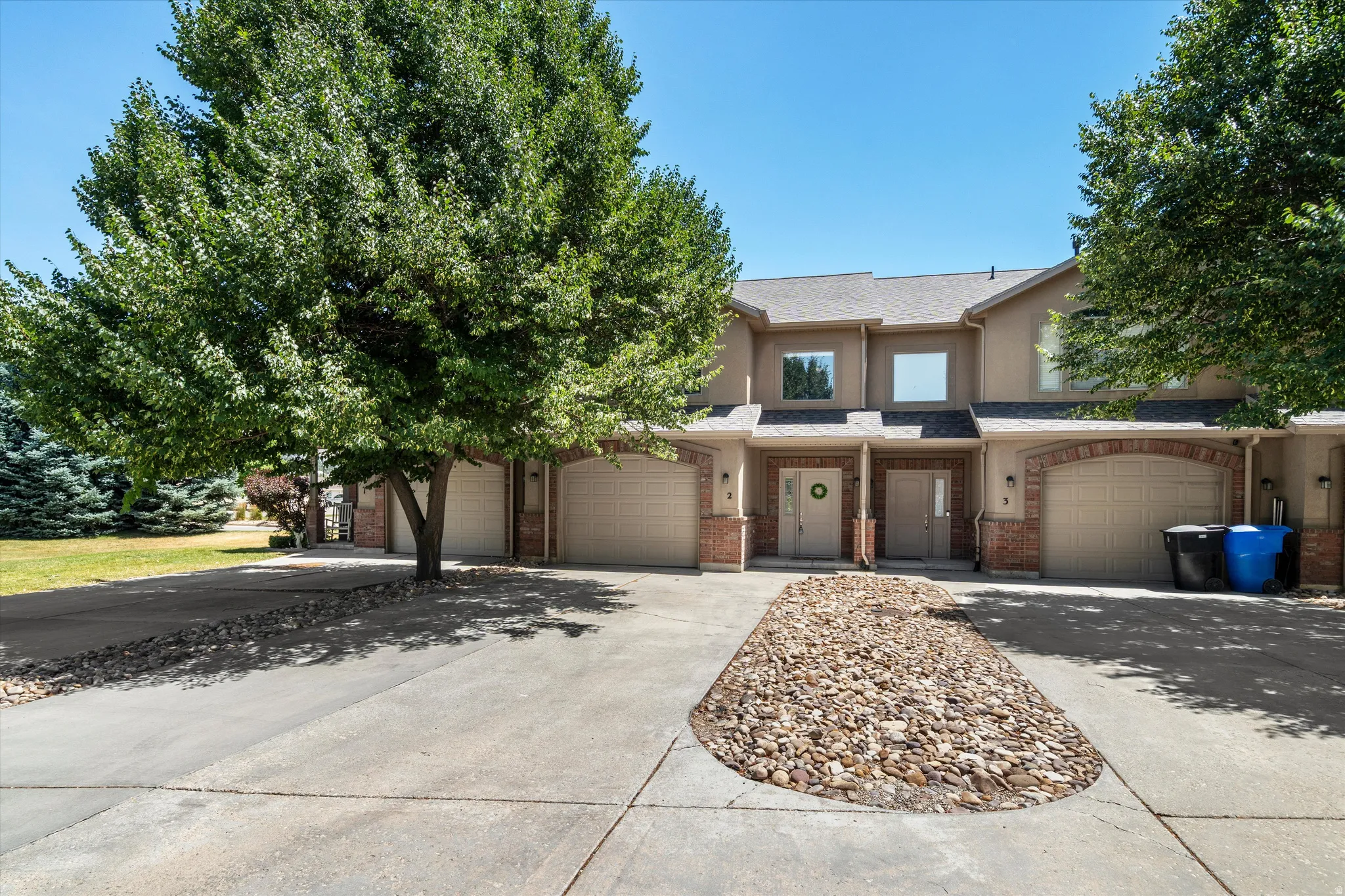 Multi-unit residential property featuring a stucco exterior and brick accents
