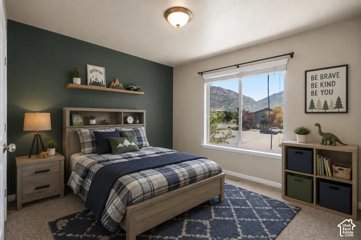 Built-in shelving, large window with mountain scenery, accent wall, wood-finish flooring, and a flush mount ceiling light