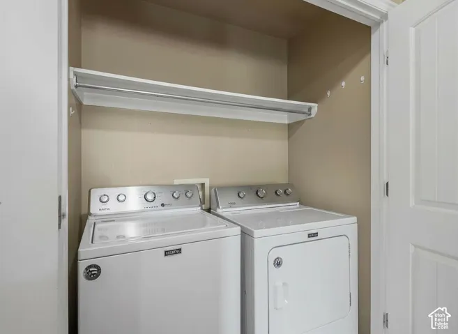 Dedicated laundry area with upper shelving and a built-in hanging rod