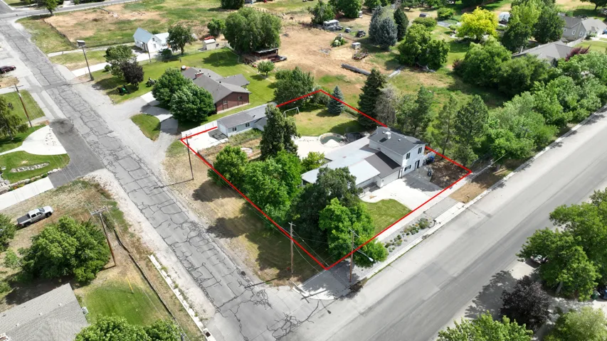 Expansive property featuring a multi-structure layout with mature trees, a swimming pool, and concrete driveways