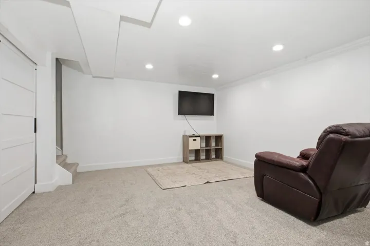 Spacious room featuring light-colored carpeting, white painted walls, and recessed lighting