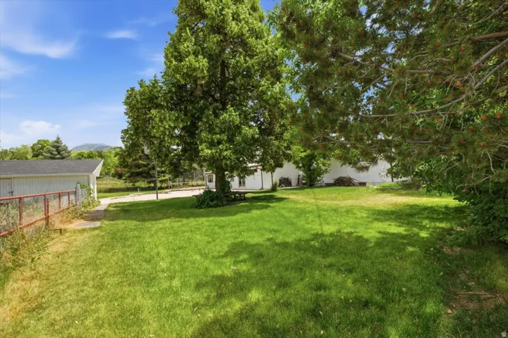 Spacious green lawn featuring mature trees and a picnic table