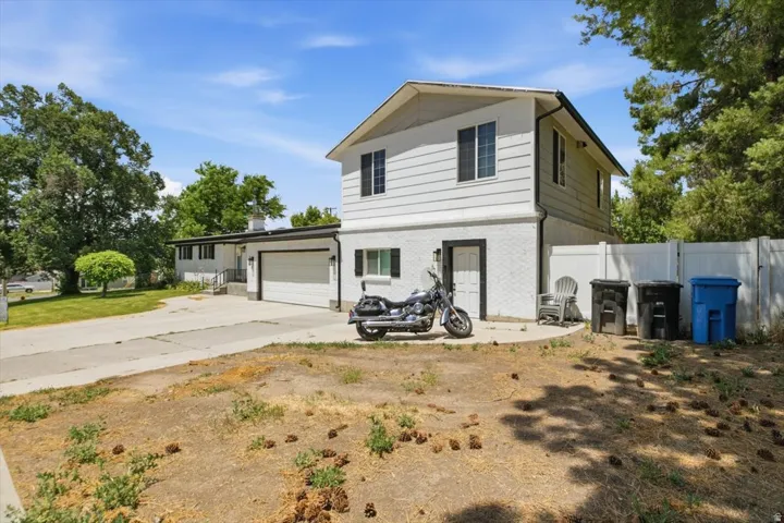 Exterior featuring white siding, white brick, and black trim accents