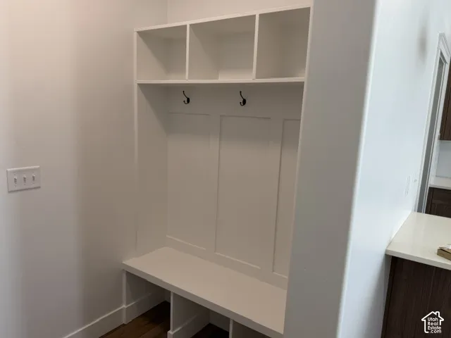 Built-in white storage bench with integrated shelving and hooks