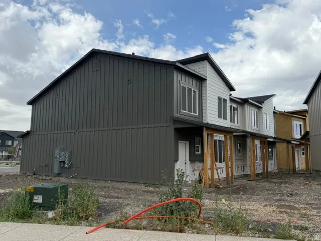 Modern townhouse exterior featuring vertical dark gray siding and white horizontal siding accents