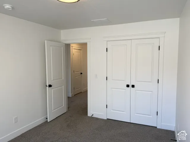 Carpeted flooring, white interior doors with dark hardware, and a semi-flush mount ceiling light fixture