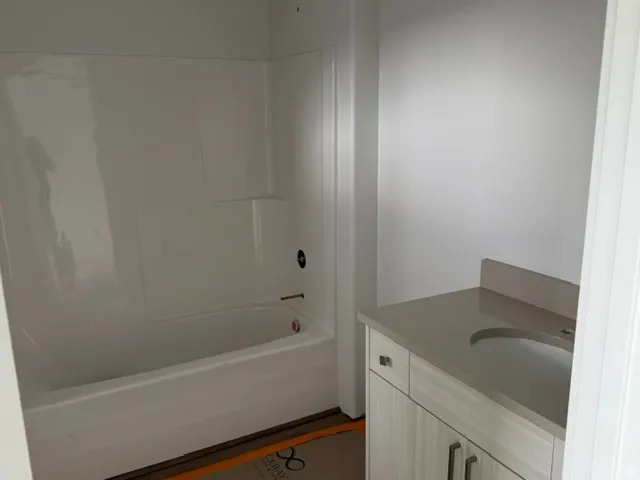 Bathroom featuring a white integrated tub and shower unit