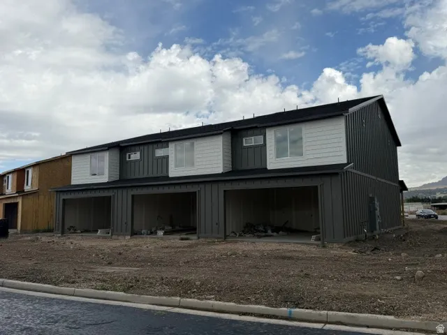 Contemporary multi-unit residence with a dark gray vertical siding facade and white horizontal siding accents