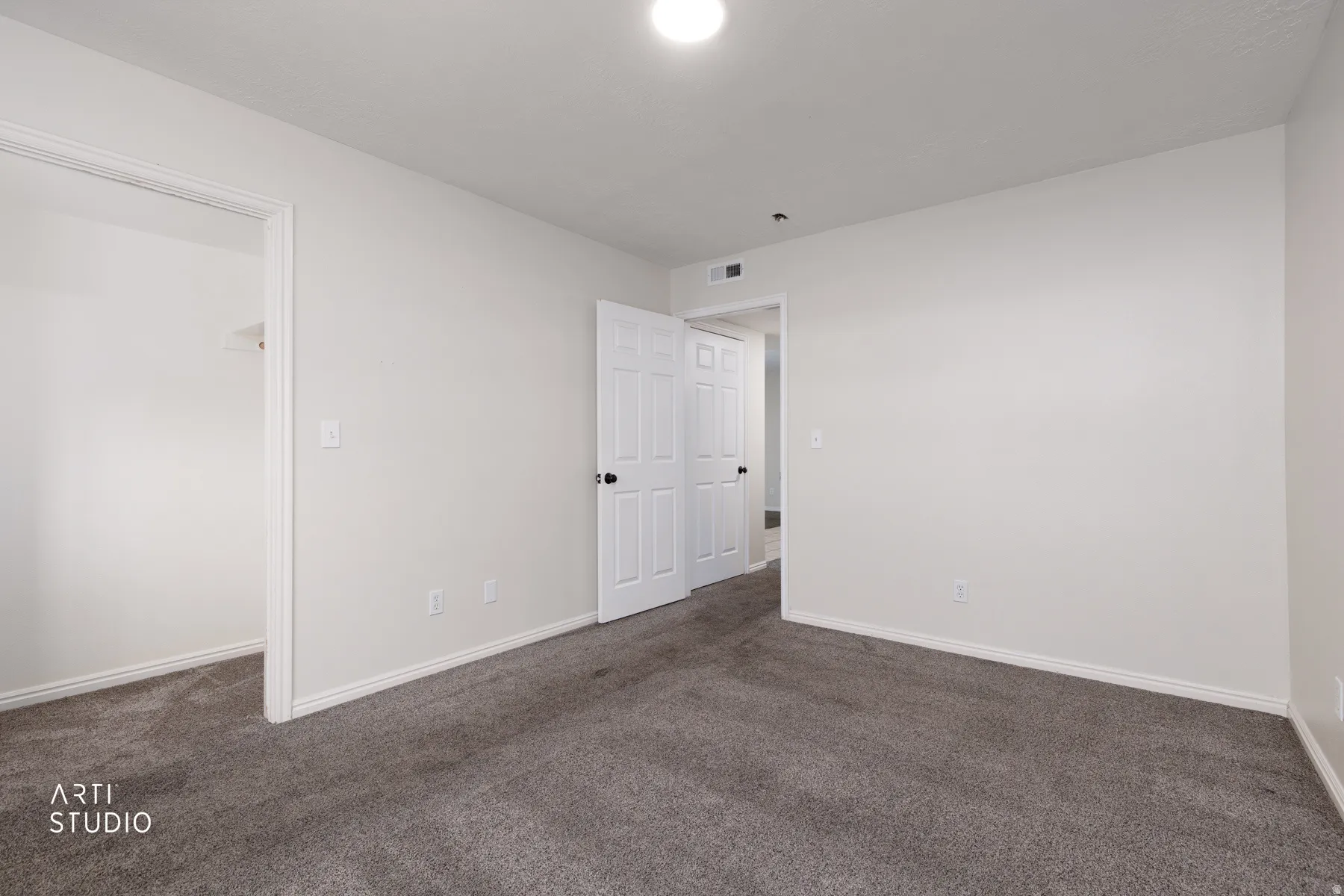 Carpeted room with white walls, white baseboards, and a flush-mount ceiling light