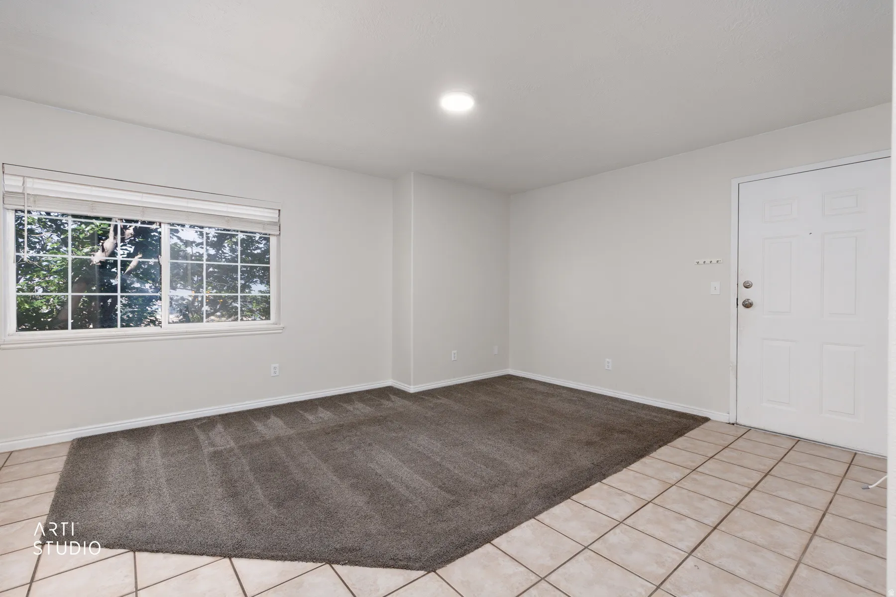 Entryway featuring a white paneled door, light ceramic tile flooring, and a recessed ceiling light