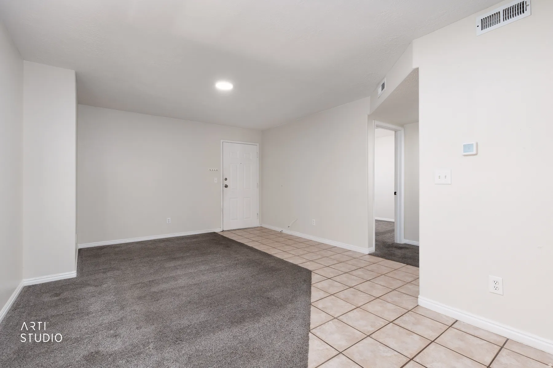 Entry area featuring light-toned square tile flooring, a white paneled entry door, and a recessed ceiling light