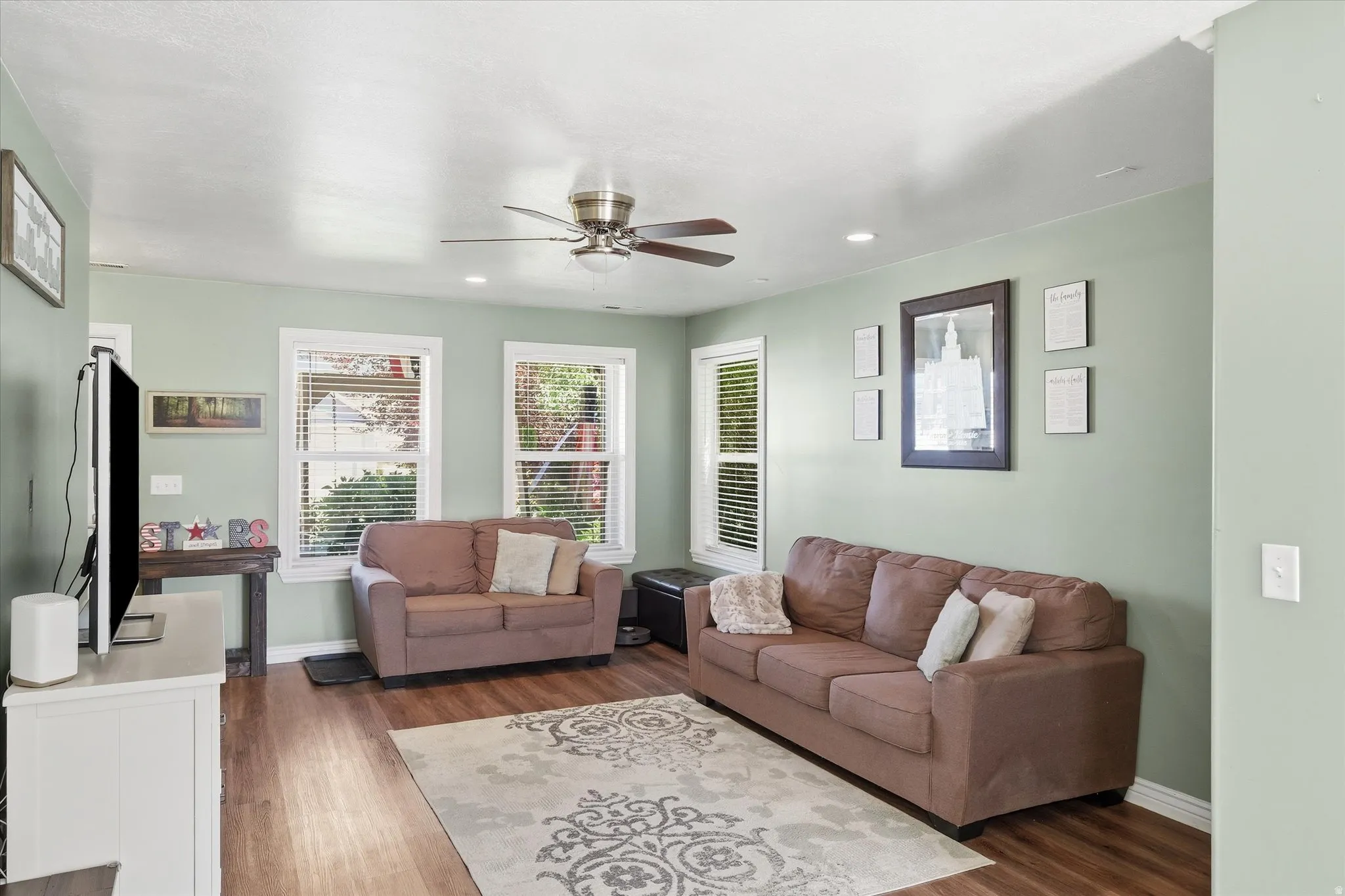 Living area featuring wood-finish flooring, recessed lighting, and a ceiling fan