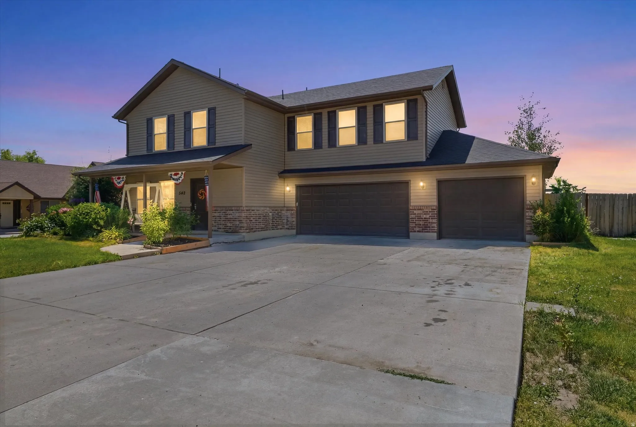 Two-story residence featuring light brown siding and stone veneer accents