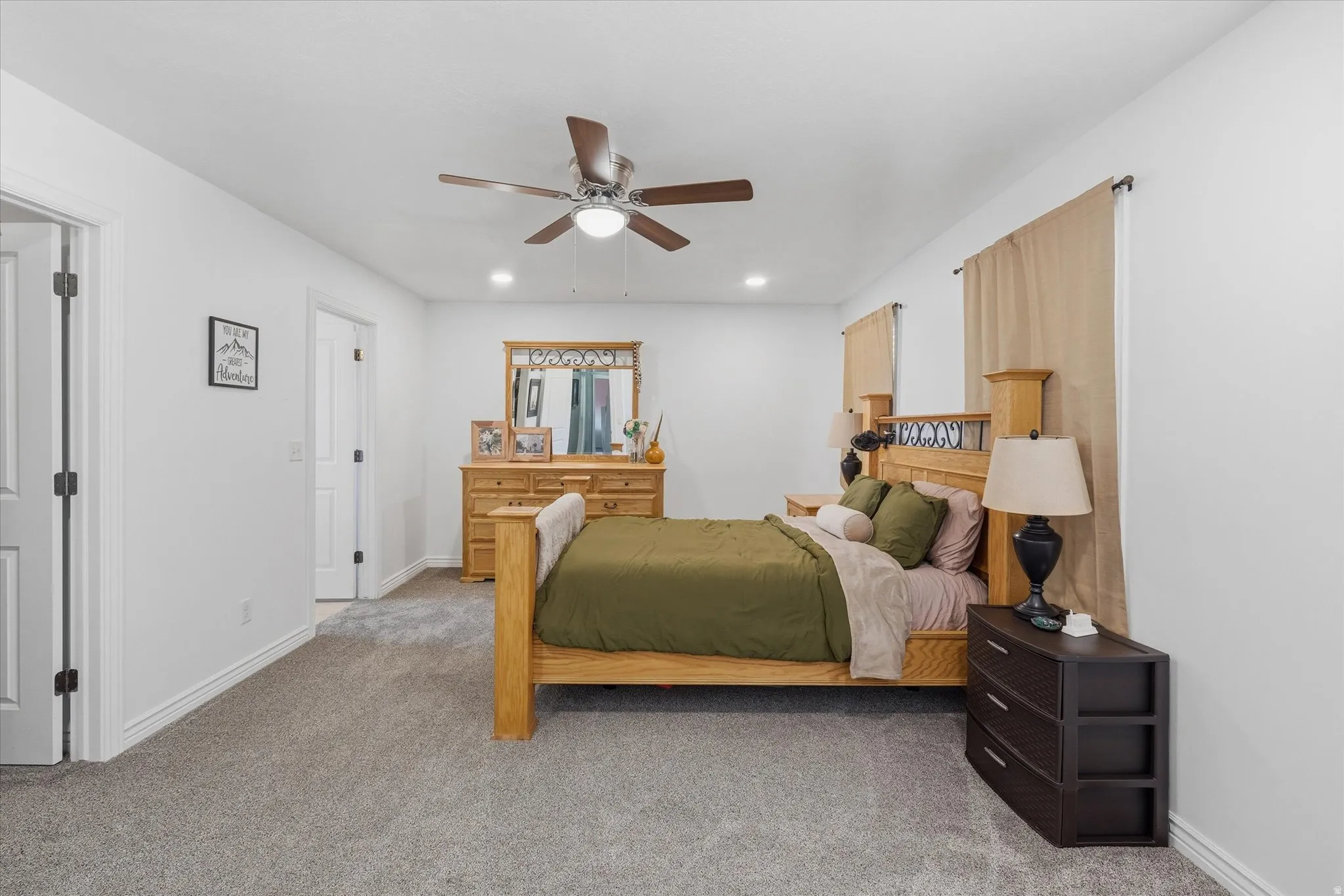 Spacious room featuring neutral carpeting, a ceiling fan with integrated lighting, recessed lighting, and white baseboards