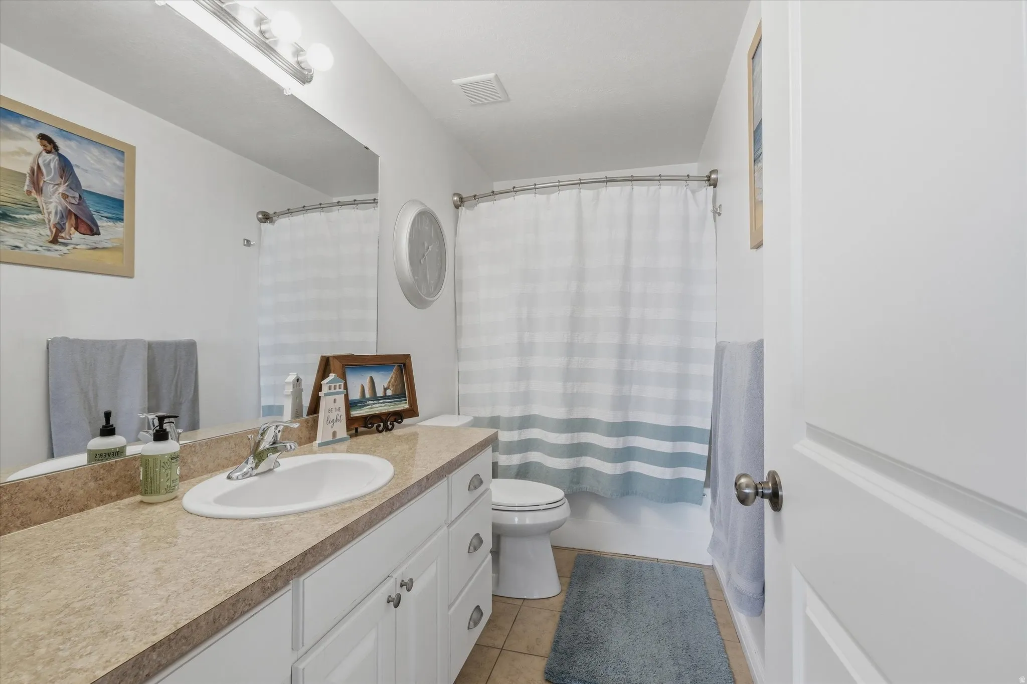 Bathroom featuring a vanity with a drop-in sink, chrome faucet, and a light-toned countertop