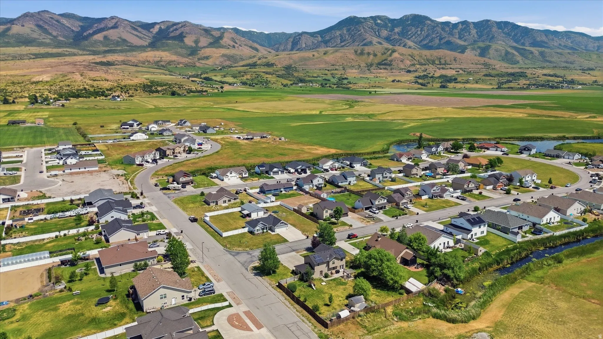 Expansive residential neighborhood with varied architectural styles, green spaces, and mountain backdrop