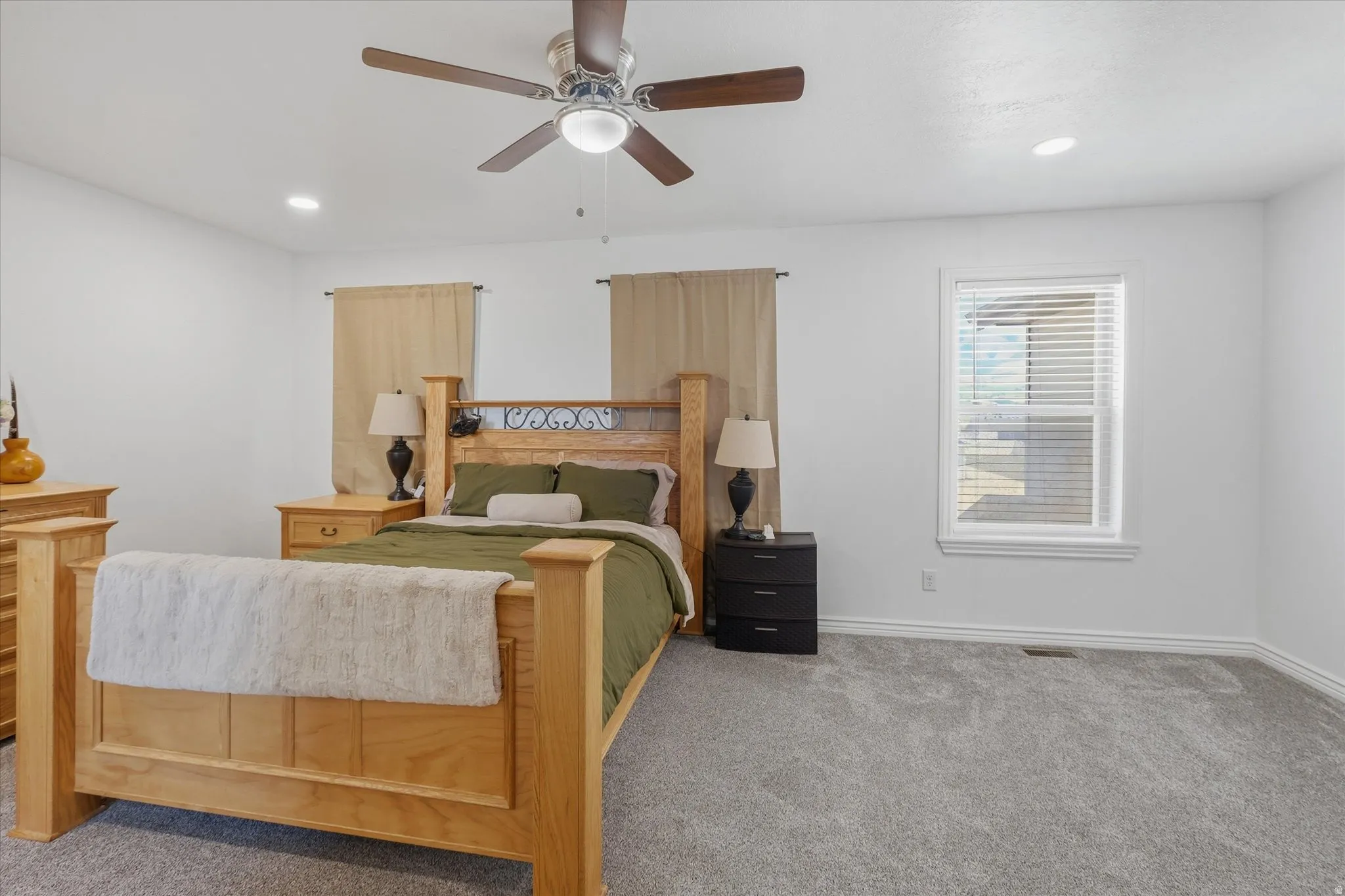Bright bedroom with recessed lighting and a ceiling fan