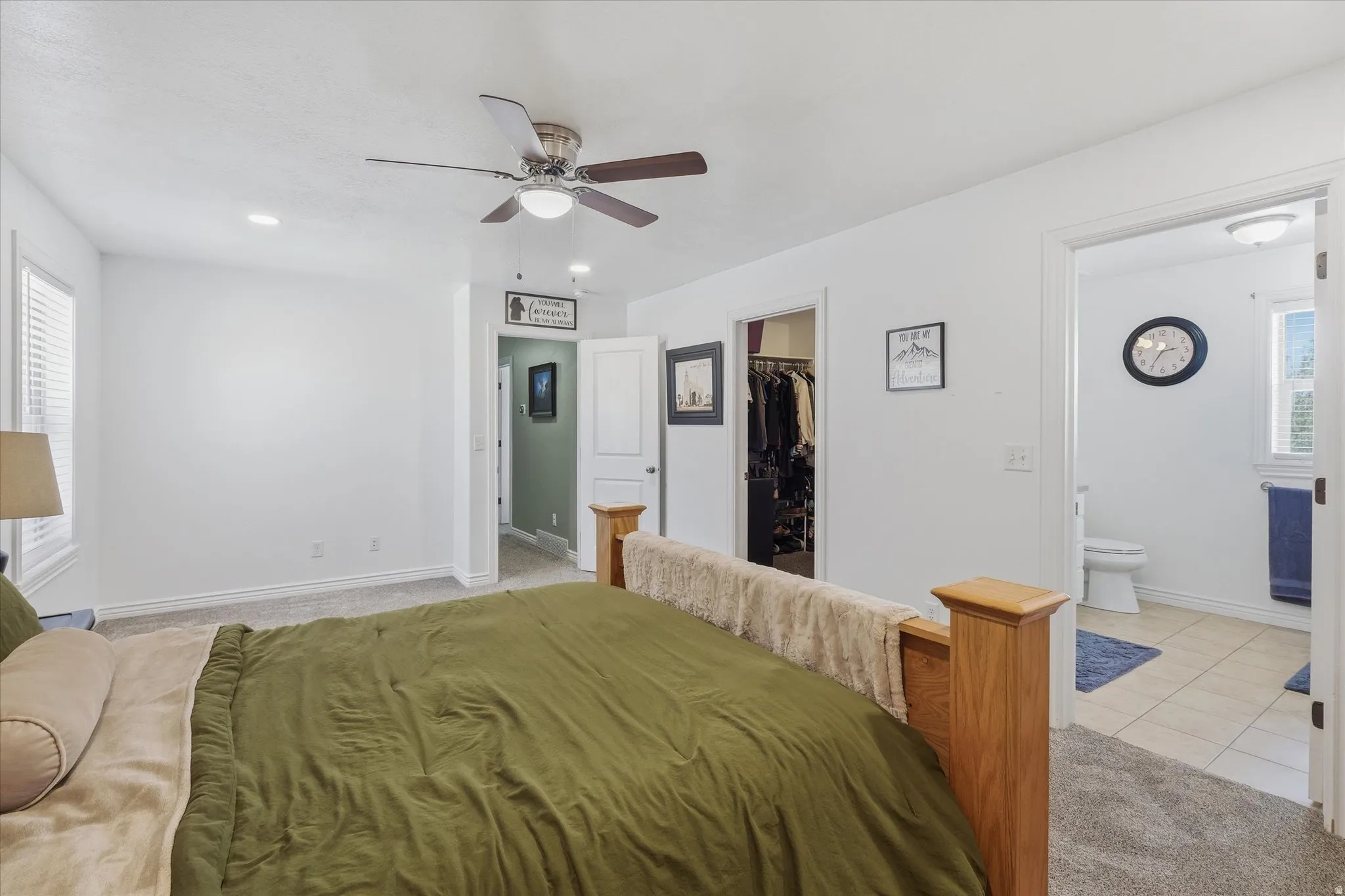 Bedroom featuring a ceiling fan with integrated lighting, carpet flooring, and a window with blinds