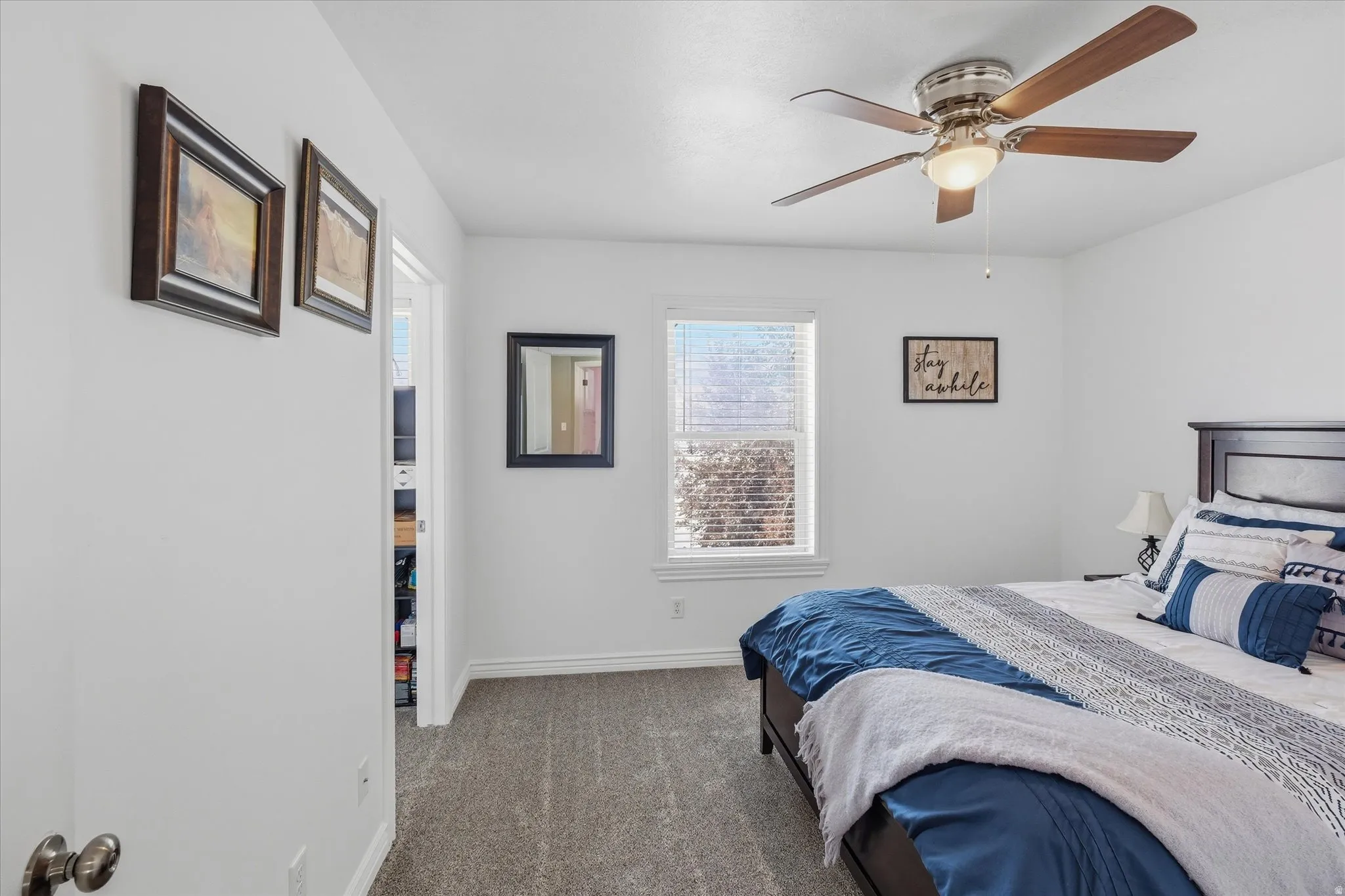 Bedroom featuring a window with blinds, a ceiling fan with integrated lighting, and carpet flooring
