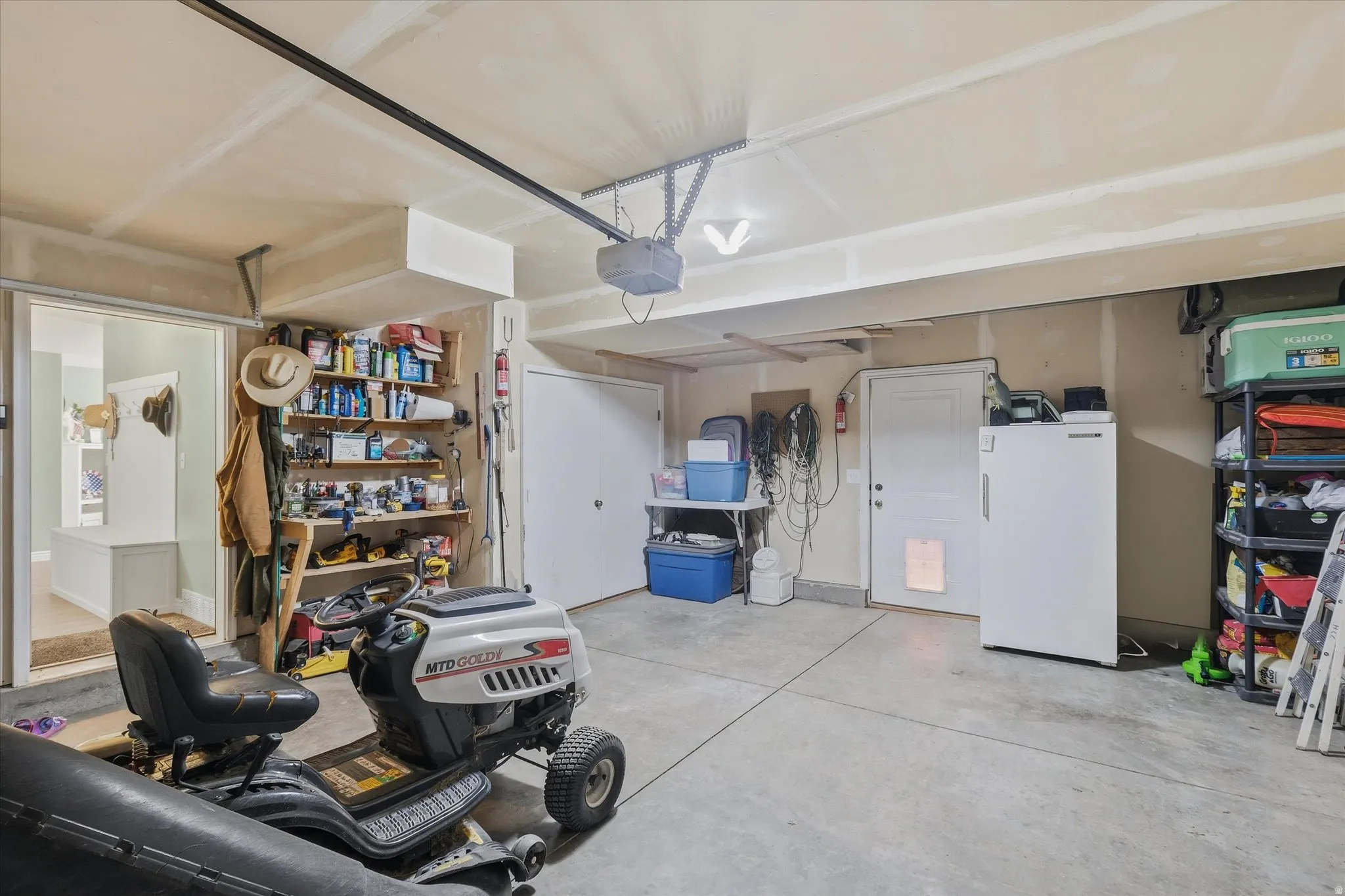 Spacious garage featuring a concrete floor, overhead lighting, and an automatic garage door opener
