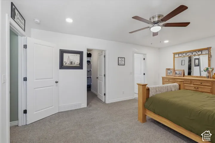 Spacious interior featuring neutral carpet flooring, recessed lighting, and a ceiling fan with light fixture