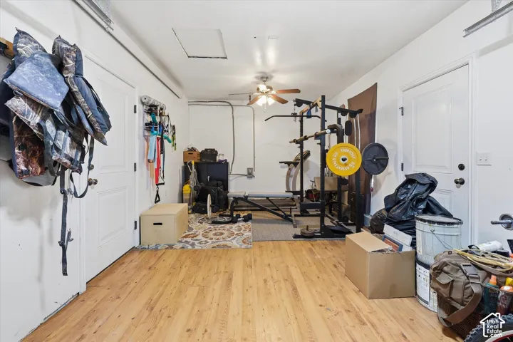 Versatile space featuring wood-finish flooring, white walls, and a ceiling fan