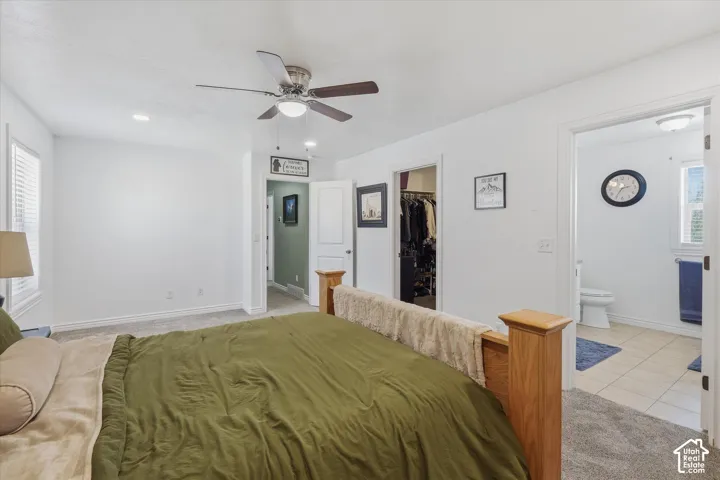 Bedroom featuring a ceiling fan with integrated lighting, carpet flooring, and a window with blinds