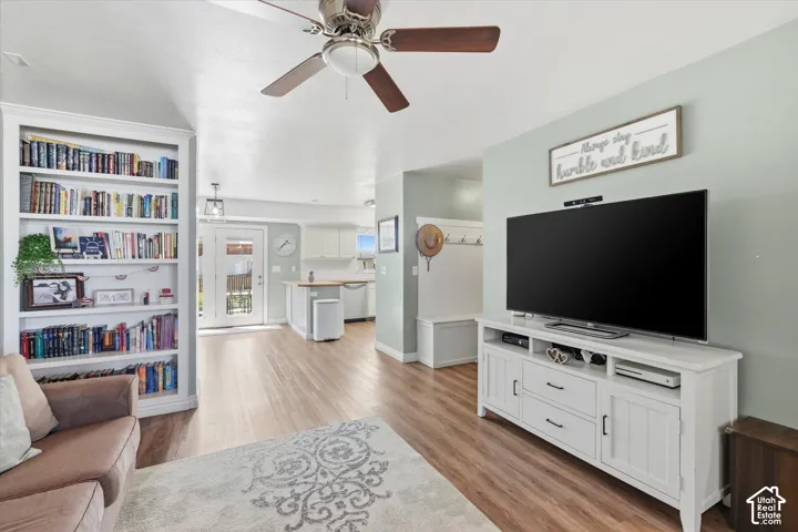 Spacious interior featuring wood-finish flooring, a ceiling fan, and built-in shelving
