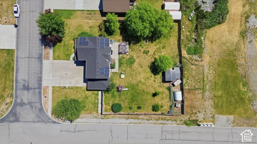 Single-story residence featuring a dark shingle roof with solar panels