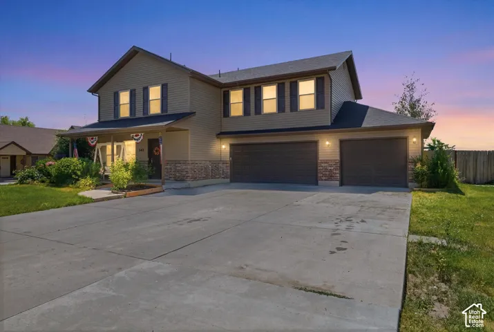 Two-story residence featuring light brown siding and stone veneer accents