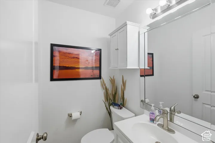 Powder room with a white single vanity, brushed nickel faucet, and a large wall-mounted mirror