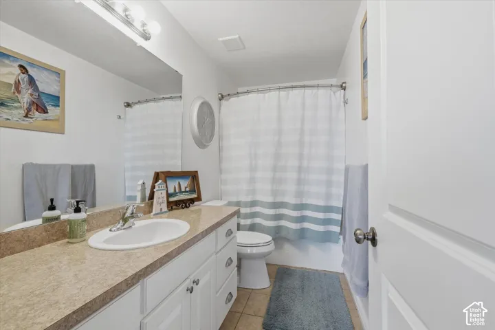 Bathroom featuring a vanity with a drop-in sink, chrome faucet, and a light-toned countertop