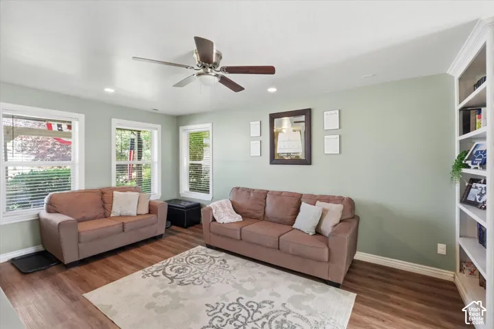 Spacious living area featuring wood-finish flooring, recessed lighting, and a ceiling fan