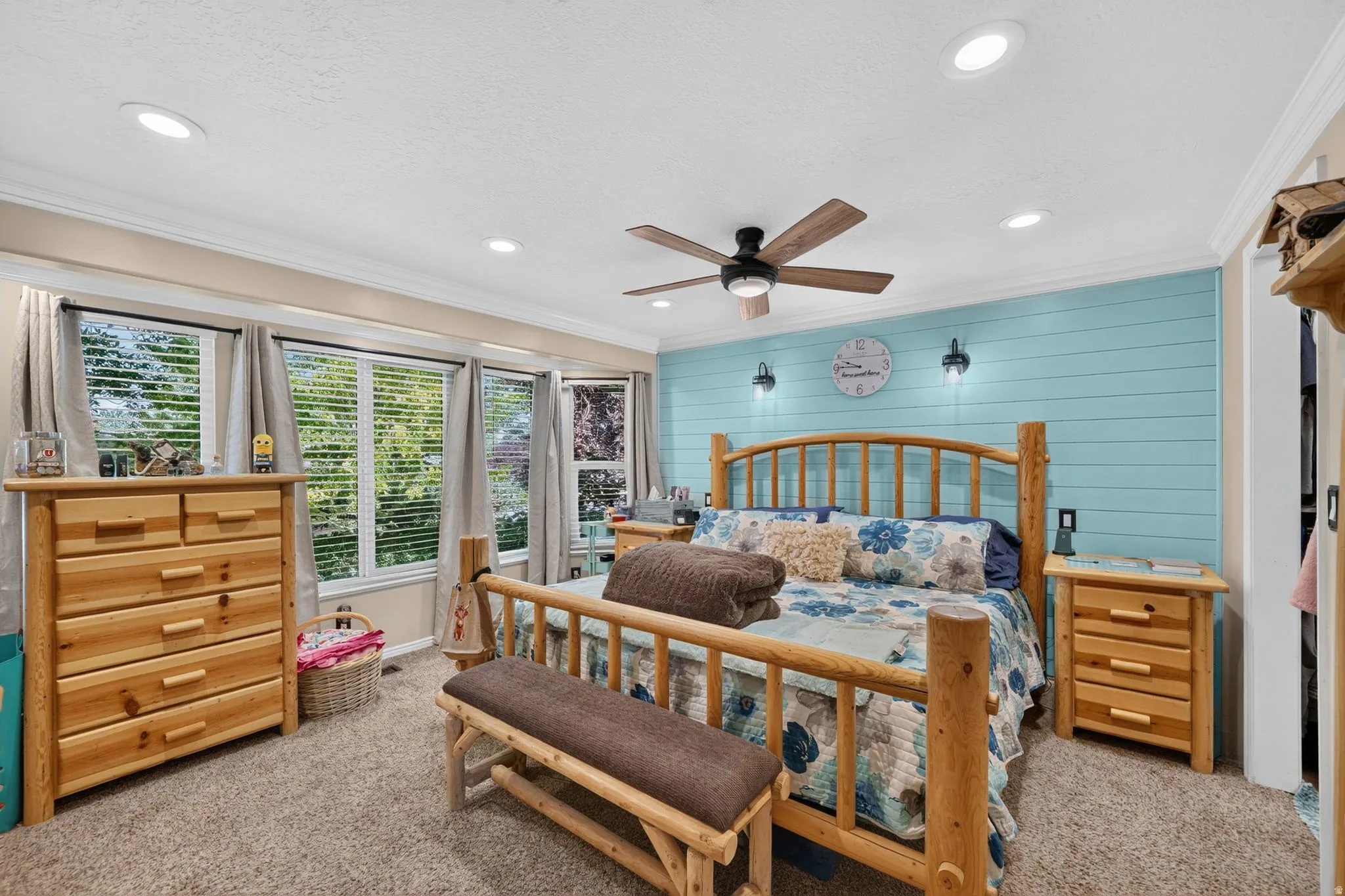 Bedroom featuring a light blue shiplap accent wall, multiple windows with blinds, recessed ceiling lighting, a ceiling fan with integrated lighting, and carpeted flooring