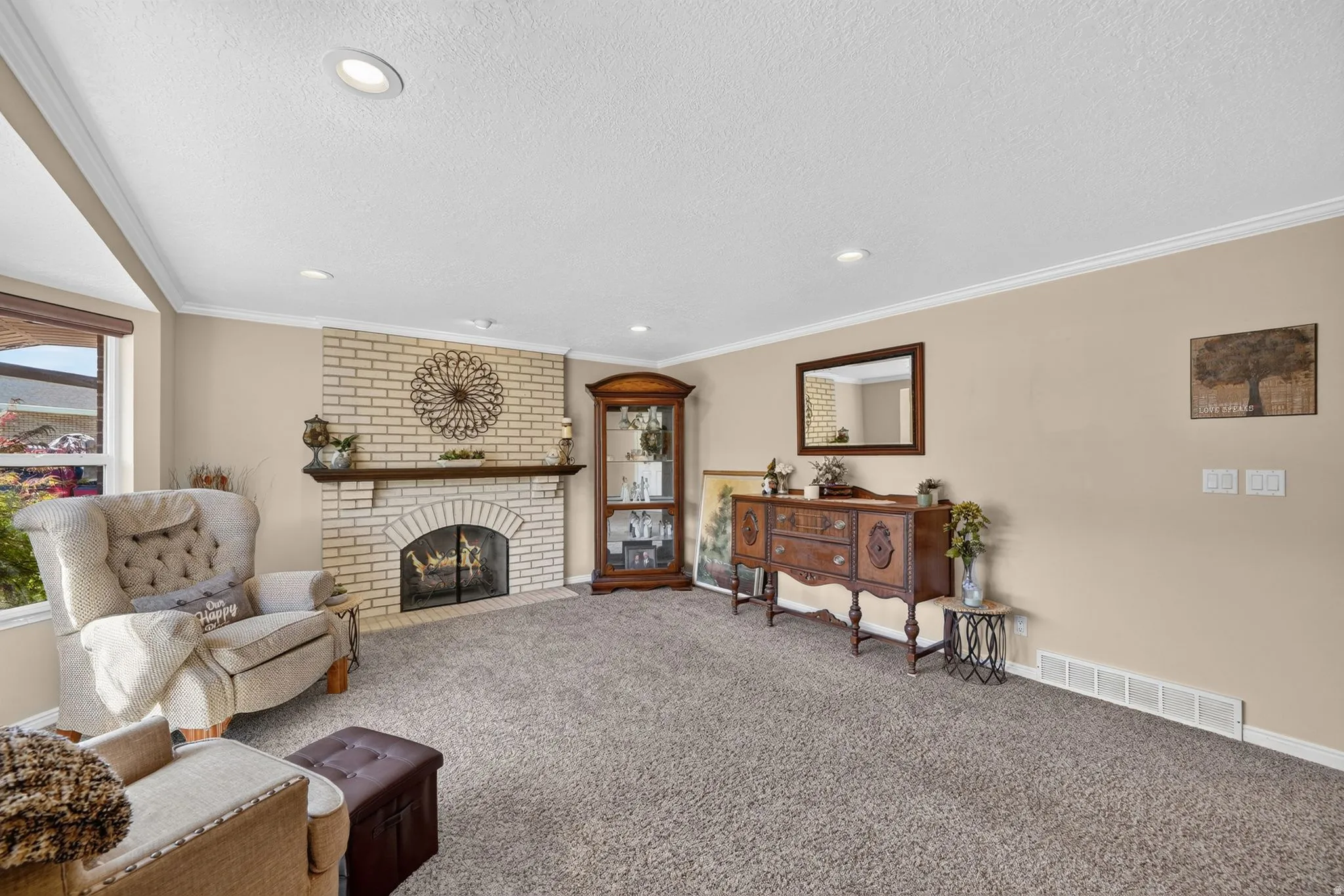 Living area featuring neutral-toned walls, recessed lighting, and crown molding