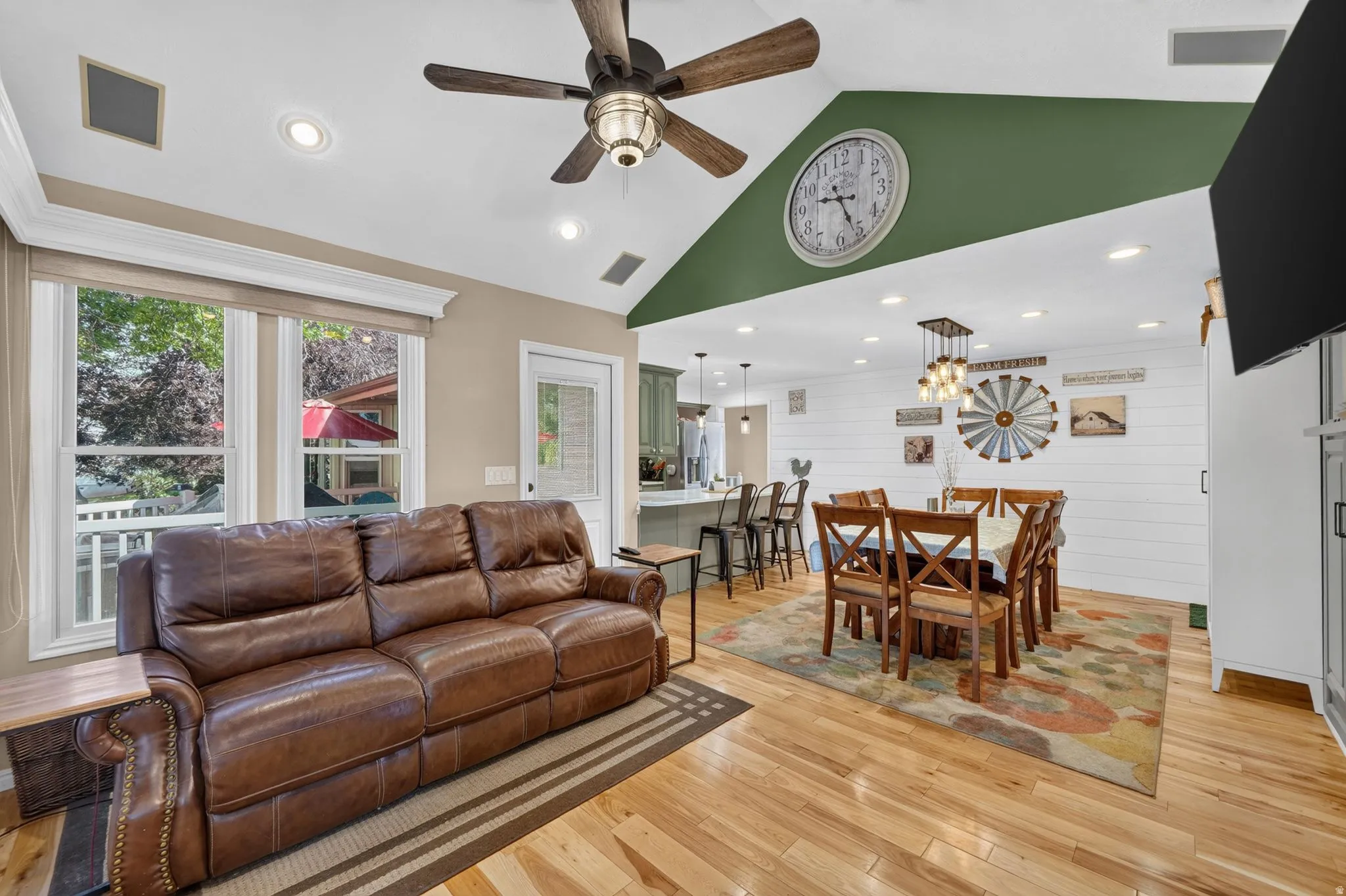 Open-concept living space featuring wood-finish flooring, recessed lighting, and a vaulted ceiling with a ceiling fan