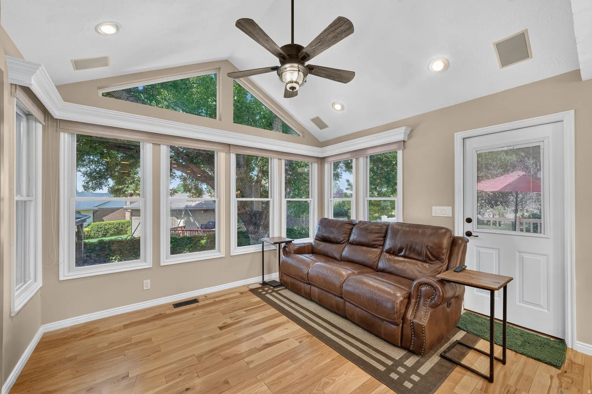 Great room with vaulted ceiling, a ceiling fan, recessed lighting, and wood-finish flooring
