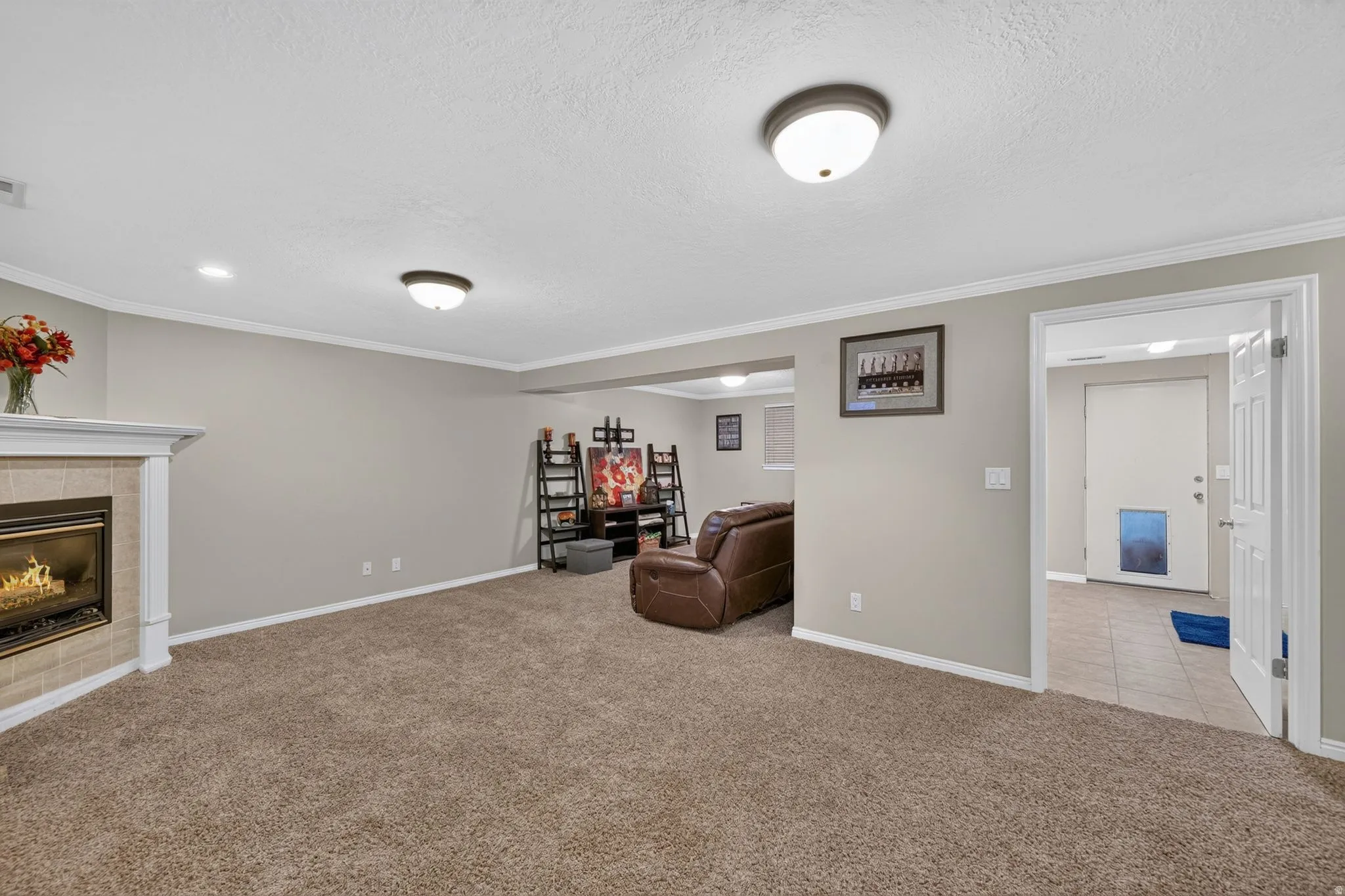 Spacious living area featuring a corner fireplace with tile surround and mantel