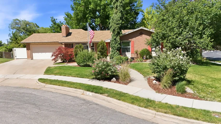 Brick exterior residence with an attached garage (concrete driveway and sidewalk)