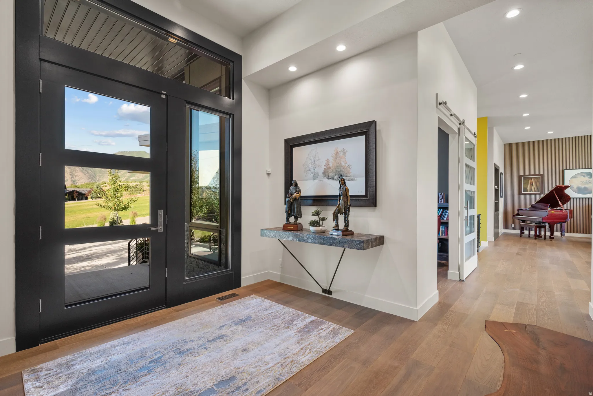 Front entry with impressive pivot door and hardwood floors
