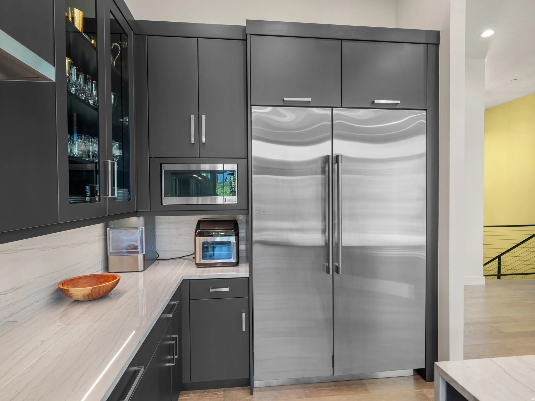 Contemporary kitchen featuring dark cabinetry, stainless steel appliances, and a light-toned countertop
