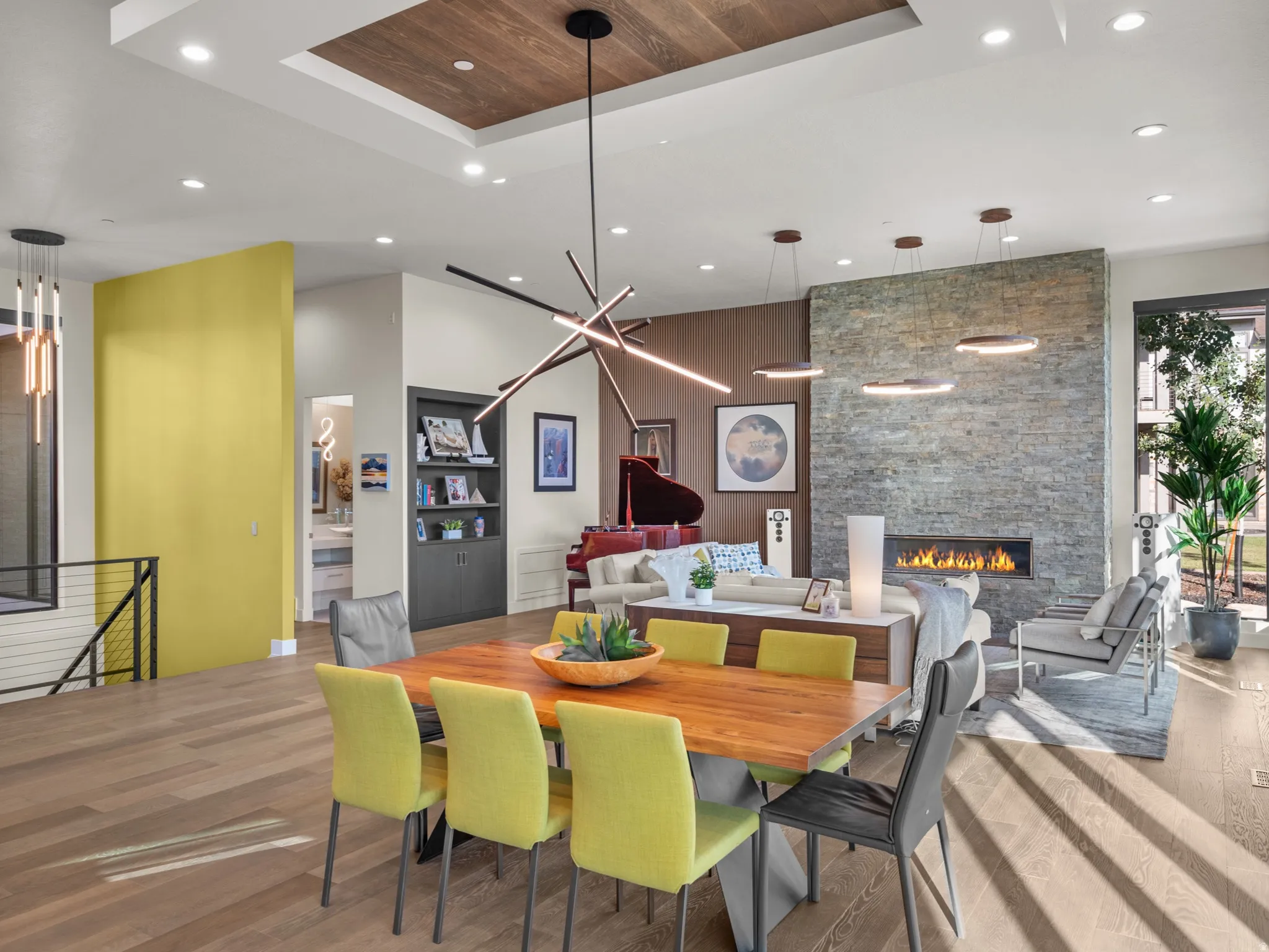 Open-concept dining and Living room with hardwood floors,  stone-clad fireplace with an integrated linear firebox