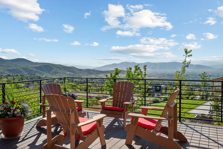 Expansive outdoor deck featuring composite decking and a black horizontal metal railing.  Unobstructed views to the valley and mountains.